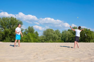 Mutlu aile yaz tatilinde iyi eğlenceler. Kumsalda spor oyunları. Etkin sağlıklı yaşam tarzı konsepti
