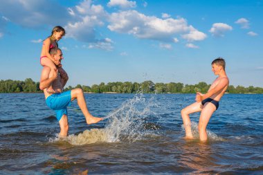 Aile güneşli bir günde nehirde oynuyor. Aile Plajı Tatil Oyunları, Tatil, Oyunlar