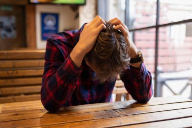 Yalnız sarhoş bir adam, depresyonda, barda ya da barda bir masada oturuyor. Alkol bağımlılığıyla savaşmak. Kriz, işsizlik, yalnızlık