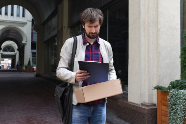 İşsiz bir işadamı, bir kutu işten çıkarılmış eşyası ile dışarıda. İş başarısızlığı konsepti ve işsizlik sorunu. Kovuldun.