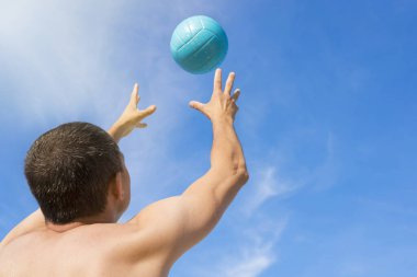 Voleybol oynayan bir oyuncunun yakın çekimi. Arkadan manzara..