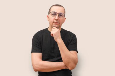 Bej arka planda kameraya bakan genç bir adamın portresi. Başarı kavramı.