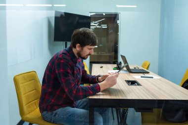 Ofisteki ofis masasında çalışan genç adam. İş, ortak çalışma.