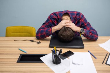 Ofisteki ofis masasında uyuyan yorgun genç bir çalışan. Girişim ve girişimcilik kavramı.