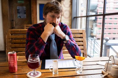 Alkolizm, alkol bağımlılığı. Depresyondaki işsiz üzgün adam barda tek başına alkol içiyor.