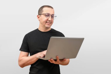 Başarılı bir genç adam, beyaz arka planda dizüstü bilgisayarla çalışan serbest bir öğrenci. Başarı konsepti