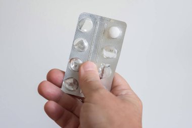 Beyaz arka planda bir paket ilaç tutan bir el. Sağlık kavramı.