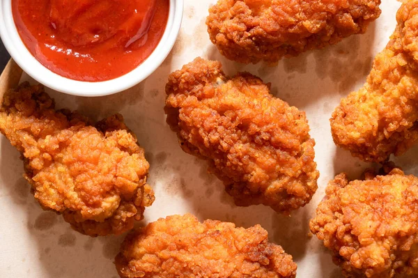 Delicious crispy breaded chicken breast strips on the table. View from above.
