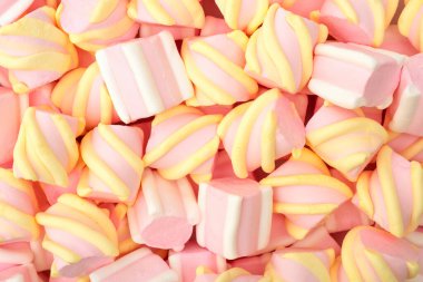 Arka plan olarak pembe ve beyaz şekerlemeler, üst manzara. Tatlı renkler, tatlı yiyecekler..