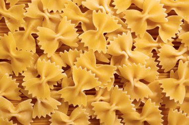 Çiğ osuruk ya da papyonlu makarna yığını. İtalyan makarnası, arka plan dokusu, üst manzara.