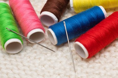 Dikiş dikerken iplik ve dikiş iğnelerinin renkli makaraları.
