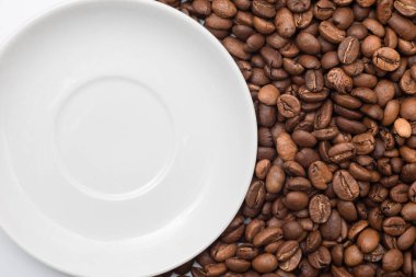 Kahve çekirdekleri ve bir tabak yakın çekim. Üst görünüm.