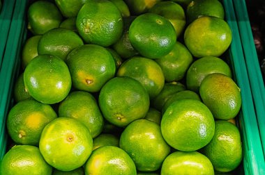 Süpermarkette bir kasa yeşil mandalina. Yeşil mandalina.
