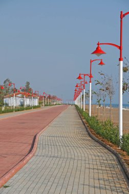 Sahilde yürüme yolu ve kırmızı sokak lambaları.