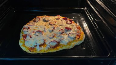 Fırında pişmiş pepperoni ve peynirli pizza..