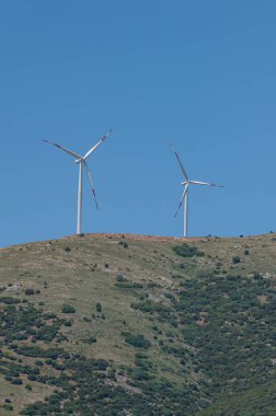 Dağın tepesinde rüzgar türbinleri.