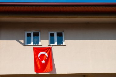 Ulusal bayramda pencerede Türk bayrağı asılı.
