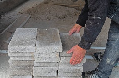 İnşaat ustabaşı briketleri taşıyor..