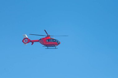 Gökyüzünde uçan kırmızı renkli helikopter.