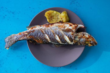 Fırında kızartılmış levrek ve yanında patates..