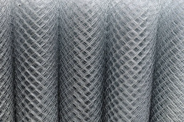 Roll of metal mesh. Rolled metal mesh netting. Rolled chain link fence. Selective focus.