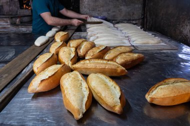 Fırıncı ekmek hamurunu fırına koydu. Türk ekmek üretim süreci.