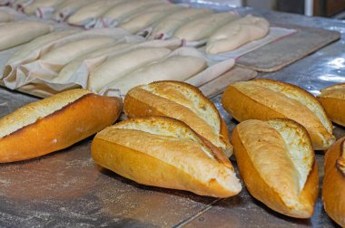 Fırında taze ekmek ve arka planda da çörekler..