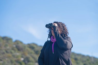 Dürbünle kuş izleyen bir kadın..