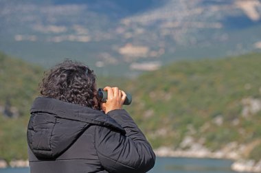 Dürbünle kuş izleyen bir kadın..