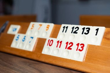 Tahta oyun, sayılar ve renkler ahşap bir zeminde. Rummikub, bir masa oyunu.