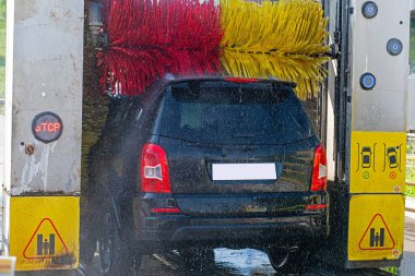 Car washing machine. Auto brush washer clean blue car on automatic carwash station. Automated car washing machine background.