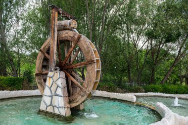 Nehirde su değirmeni çarkı ve şelale. Sürdürülebilir enerji ve su gücü geleneksel makineler.