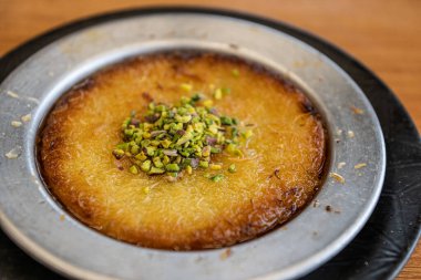 Delicious traditional Turkish kunefe with pistachio on it. Served hot and with syrup. Turkish Kunefe, Hot and Cheesy Southeastern Dessert. clipart