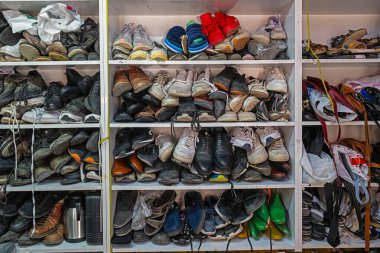 Ayakkabı tamircisinin raflarında bekleyen eski ayakkabılar..