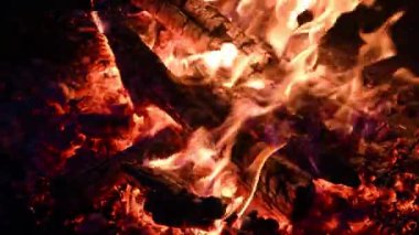 Şöminede yanan odunların yakın çekimi, barbekü ateşi, kömür arka planı. Ateşe körükle gitmek. Kamp ateşi.