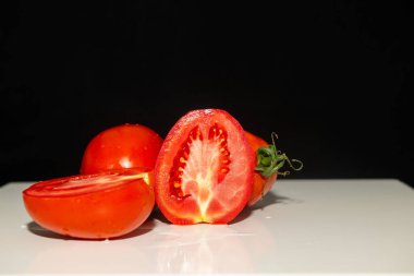 Beyaz arka planda kırmızı domatesleri yıkayıp dilimlemiş. Siyah arkaplan.