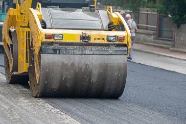 Yol yapım ve onarım çalışmaları sırasında paten ve asfalt kaldırım makinesi işletimi.