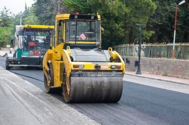 Yol yapım ve onarım çalışmaları sırasında paten ve asfalt kaldırım makinesi işletimi.