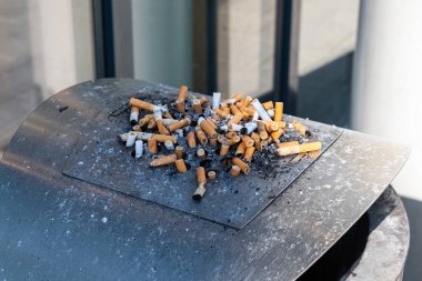 Sigara izmaritlerinden çıkan çöplerle dolu kül tablası kirliliği.