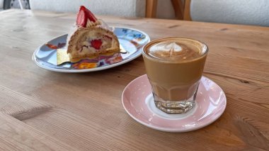 Cortado içkisi ve Budapeşte tatlısı ahşap bir masada servis edilir..