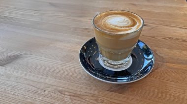 Ahşap masada servis edilen bir Cortado içeceği..