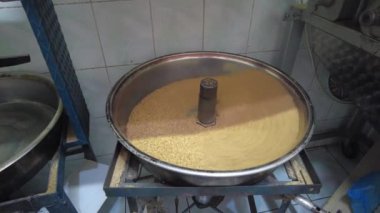 Haşhaş tohumları ezilmek ve tatlı yapmak için büyük bir kasede kızartılır..