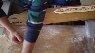 Pita ustası fırında pişirilmesi için hamurun üzerine et ve peynir koyar. Türk usulü pizza.