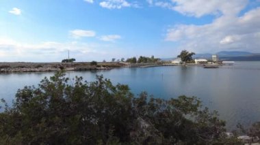 Mavi ve beyaz bulutlu gökyüzü, dingin bir göl ve dağlar. Beymelek, Antalya, Türkiye.