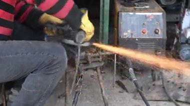 Demirci, metali elektrik spiraliyle düzleştirirken kıvılcımlar uçuşuyor..