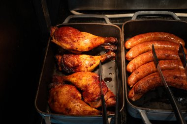 Kızarmış tavuk budu ve ızgara sosis sıcak servis için hazır. Hızlı servis ve lezzetli et çeşitleri..