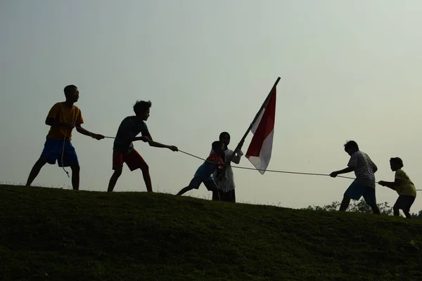 Çocuklar kırmızı ve beyaz bayrak taşırken koştu, Endonezya ulusal bayrağı. Mangerang, 6 Ağustos 2023.