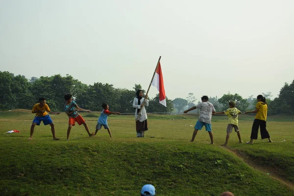 Çocuklar kırmızı ve beyaz bayrak taşırken koştu, Endonezya ulusal bayrağı. Mangerang, 6 Ağustos 2023.