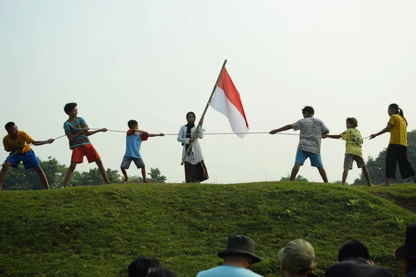 Çocuklar kırmızı ve beyaz bayrak taşırken koştu, Endonezya ulusal bayrağı. Mangerang, 6 Ağustos 2023.