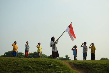 Endonezya 'nın 78. bağımsızlık günü olan 17 Ağustos 2023, 6 Ağustos 2023 tarihli Endonezya ulusal bayrağına saygı gösteren çocuklar.